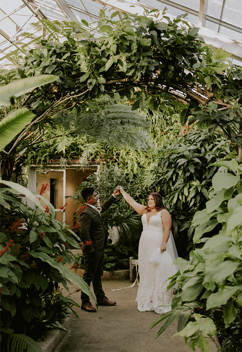 gif of bride being twirled by groom dancing under plants