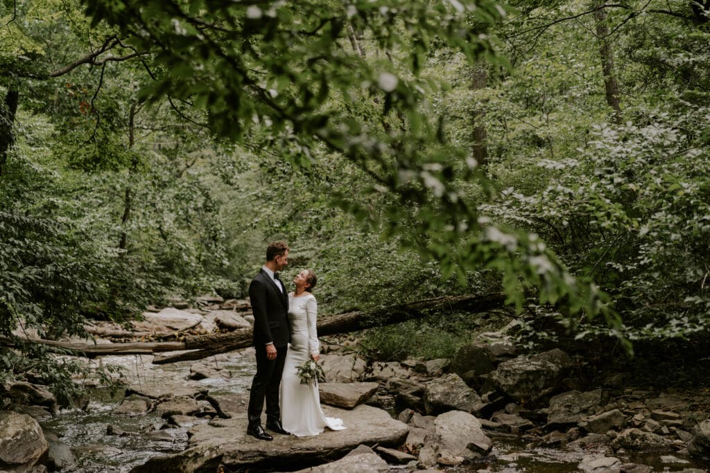 Bride and groom in creek surrounded by nature