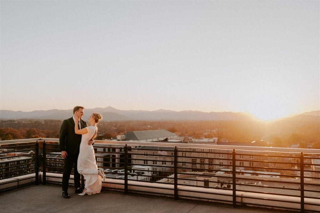 Bride and groom first look on rooftop overlooking Asheville with mountains in background