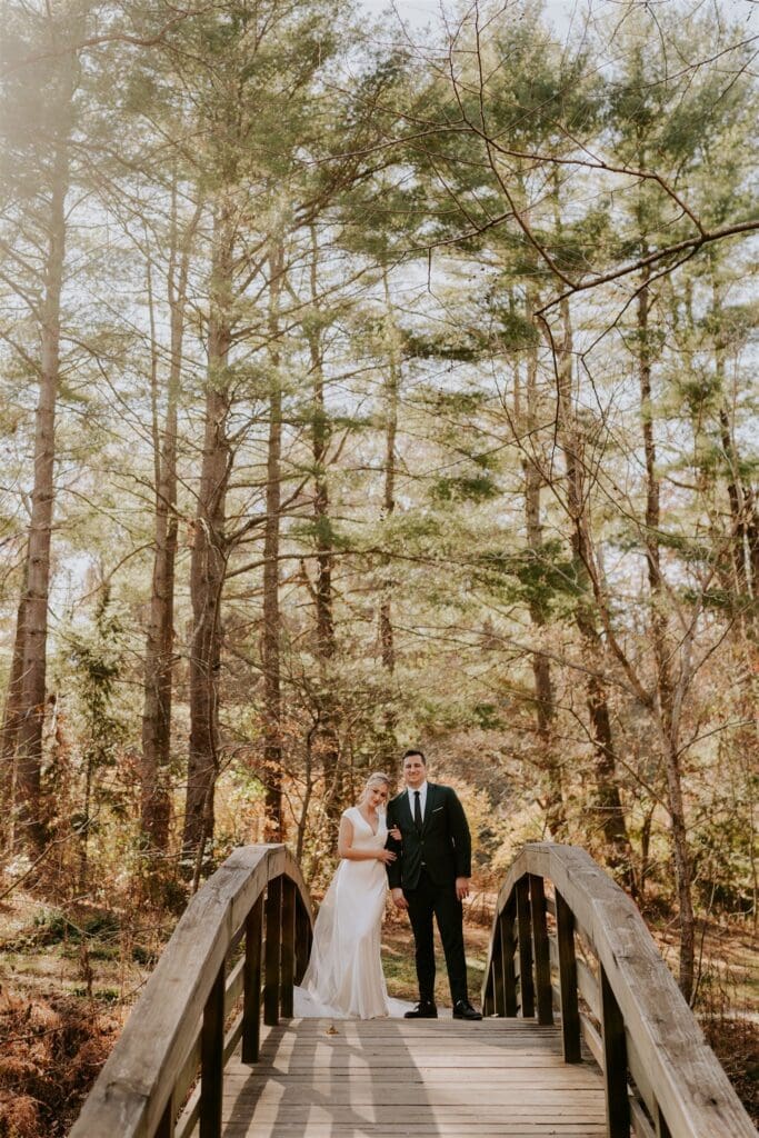 bride and groom on foot bridge in the forest outside of asheville, nc 