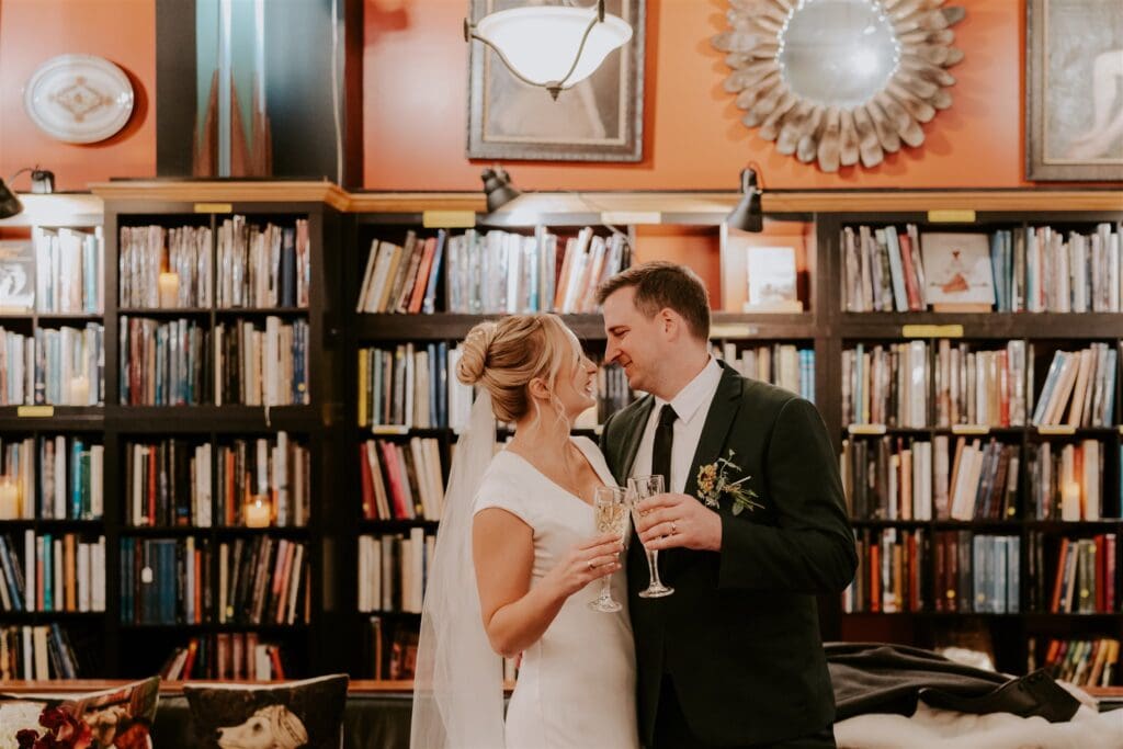 bride and groom toasting champagne at asheville book exchange