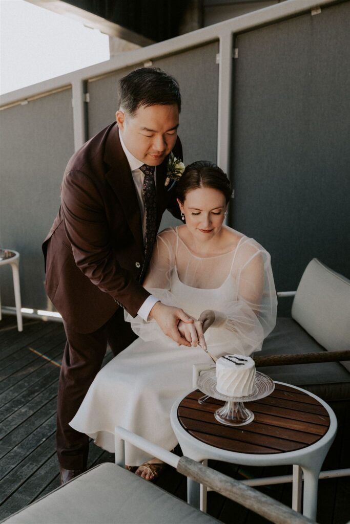 bride and groom enjoying champagne and cake on the balcony of their hotel