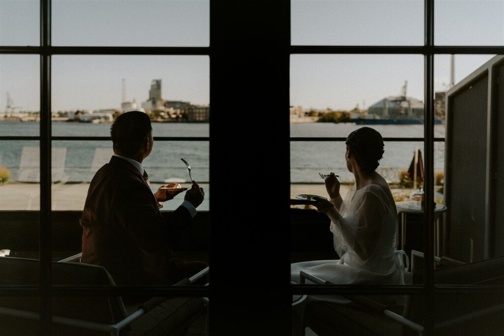 bride and groom enjoying champagne and cake on the balcony of their hotel
