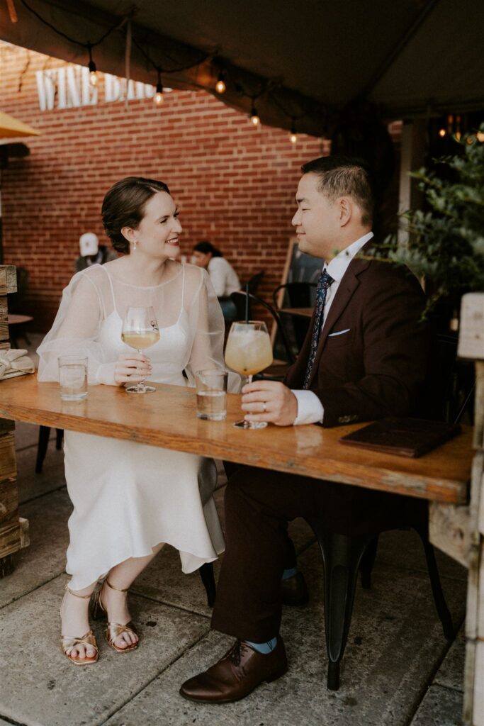bride and groom sipping drinks at the vino wine bar