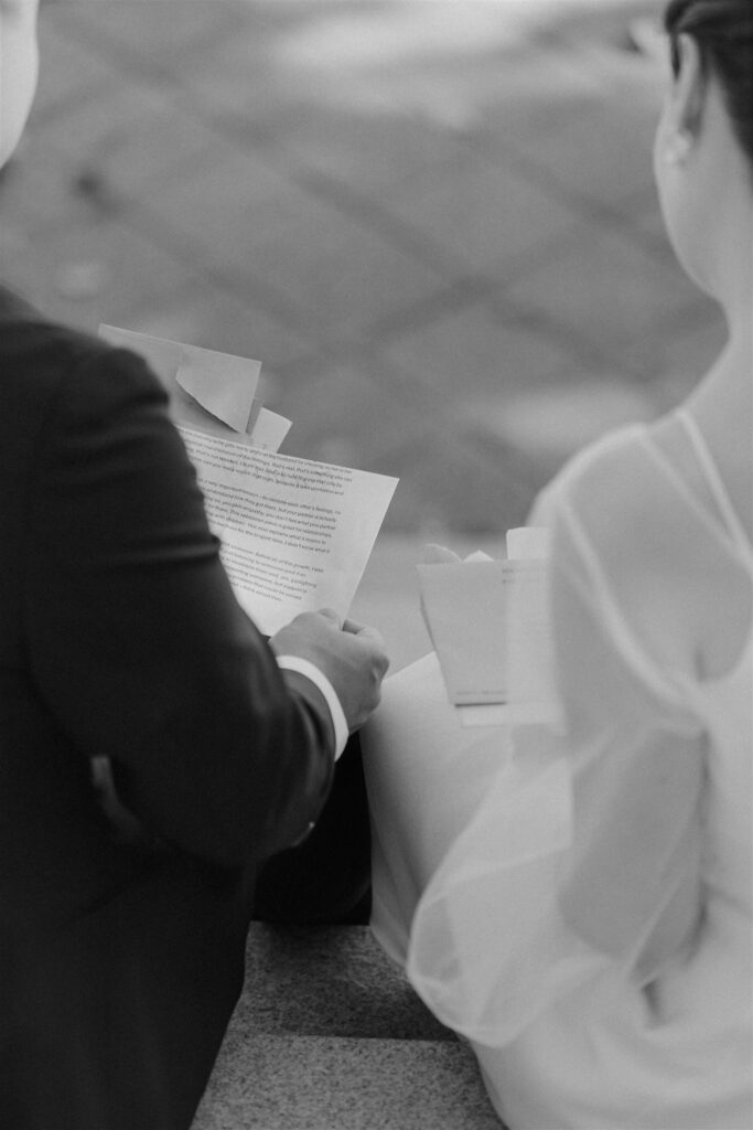 bride and groom reading private letters on the steps in front of the zoo during their baltimore zoo wedding day