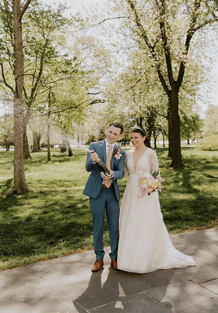 bride and groom popping champagne