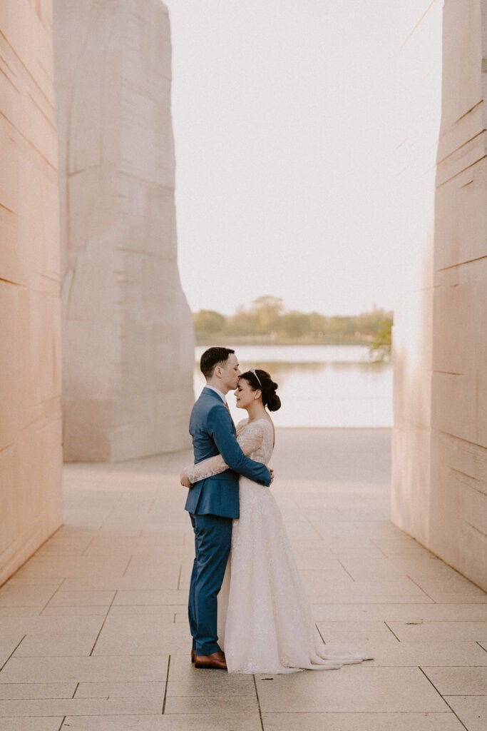 bride and groom walking around in tidal basin during their dc cherry blossom wedding