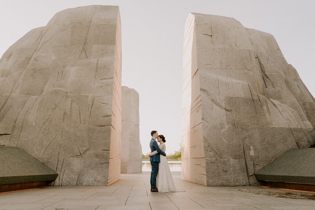 bride and groom walking around in tidal basin during their dc cherry blossom wedding