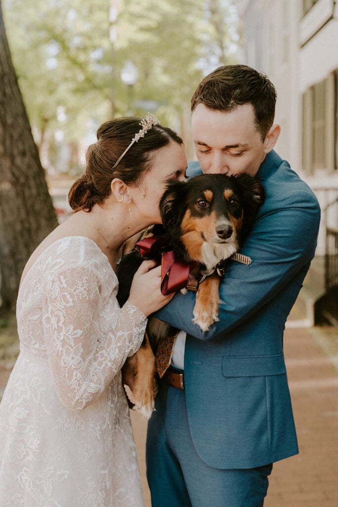 bride and groom snuggling their dog