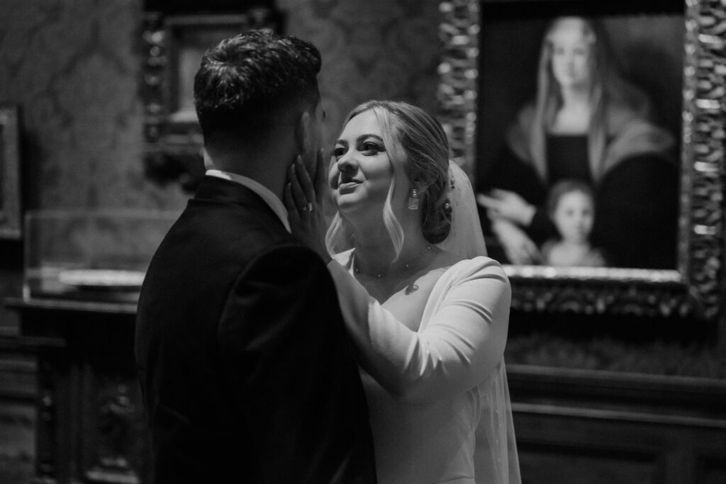 bride and groom posing in front of art at the walters art museum