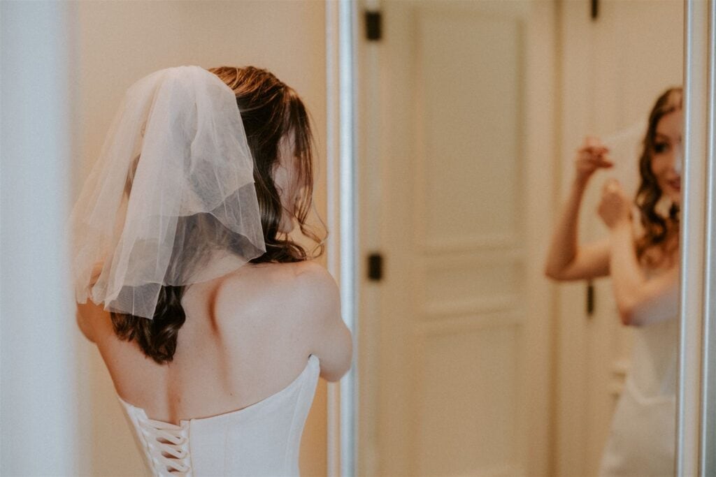 bride getting ready in front of the mirror at the hotel
