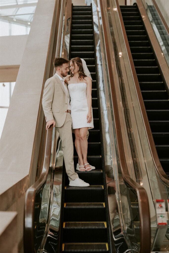 bride and groom going down on an escalator