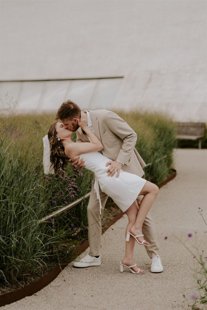 bride and groom dip kiss in front of the kennedy center in washington dc
