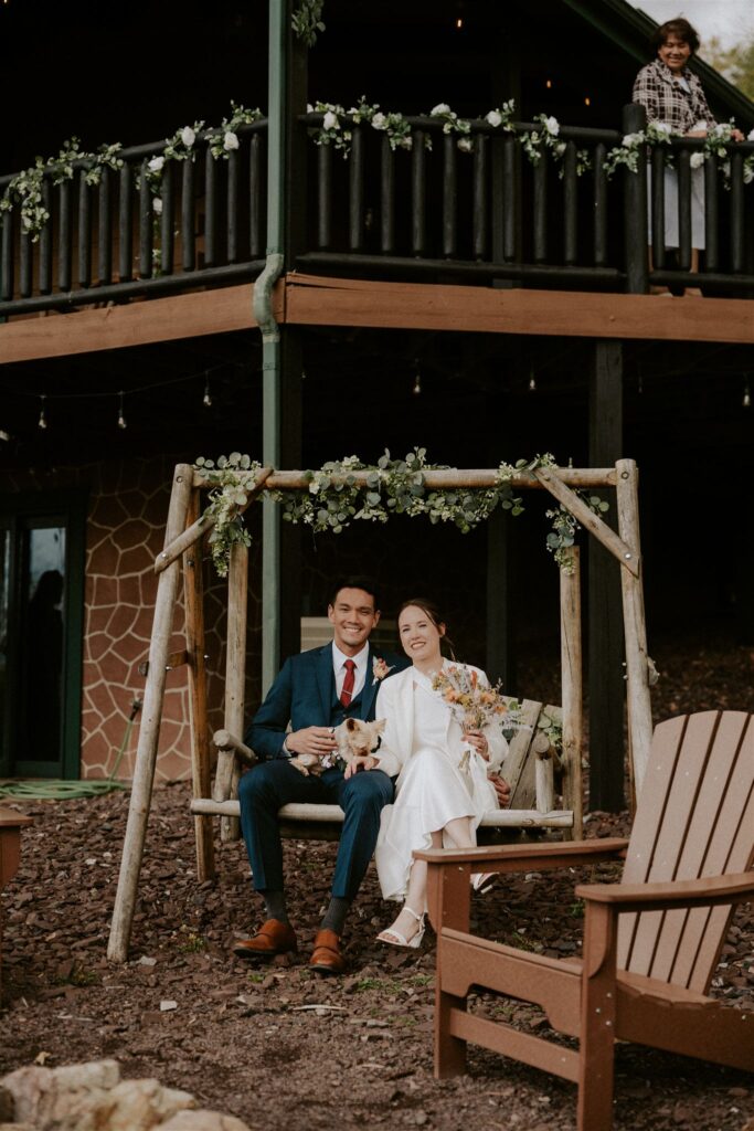 bride and groom sitting on wooden swings at their airbnb in shenandoah
