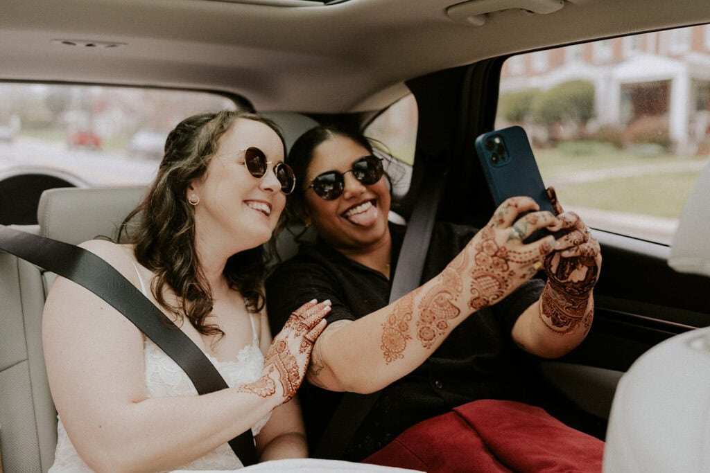 candid bride moment taking a selfie at the back of the car