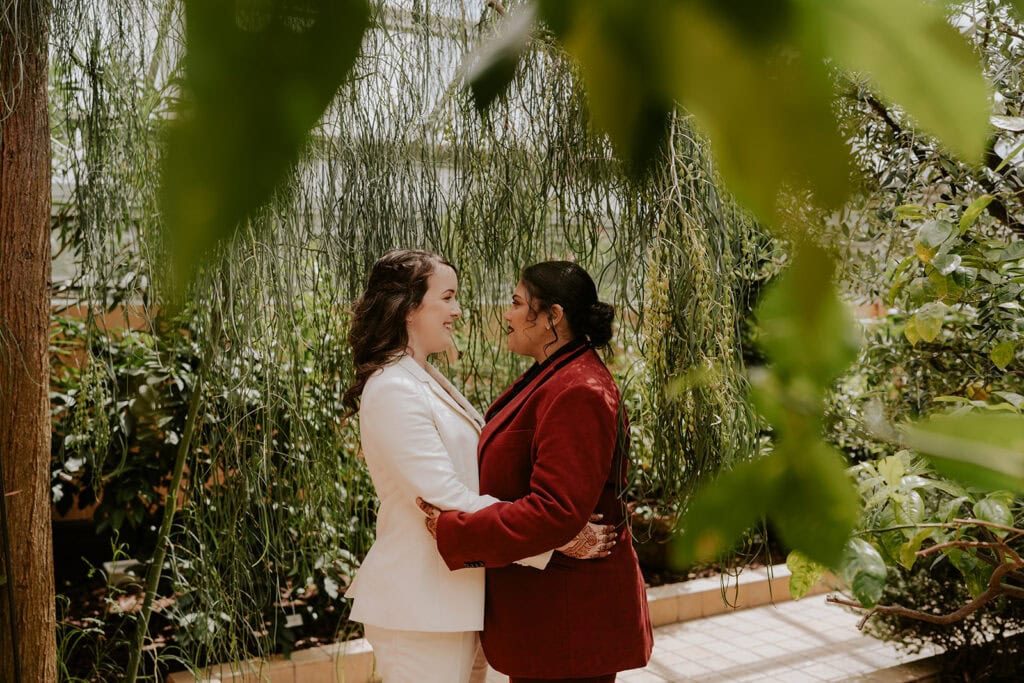 An Intentional Baltimore Elopement Rooted in South Asian Wedding Tradition 59 brides gazing lovingly at each other at rawlings conservatory