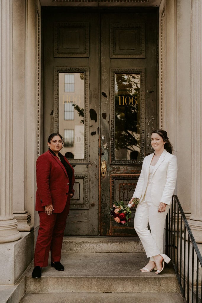 brides posing in front of an apartment building