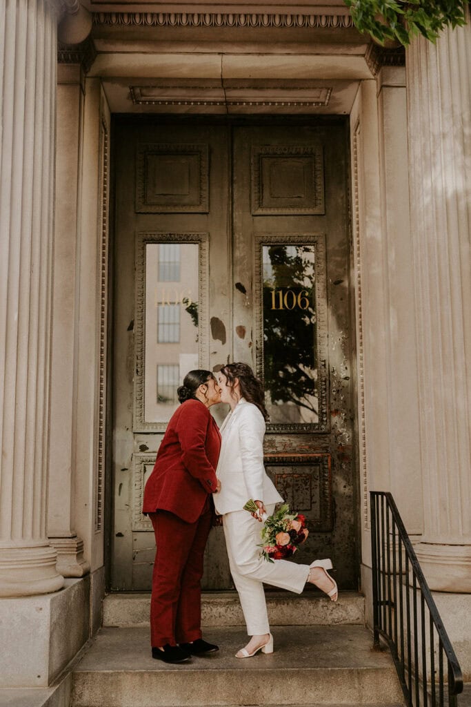 brides posing in front of an apartment building