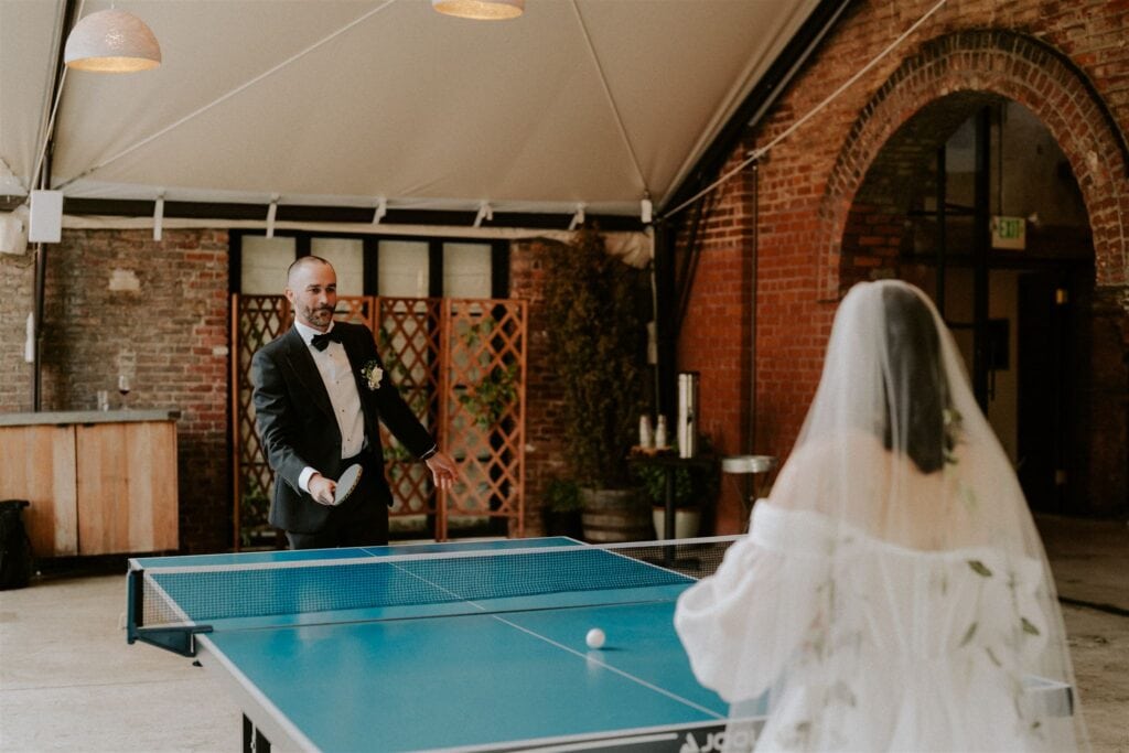 bride and groom playing ping pong